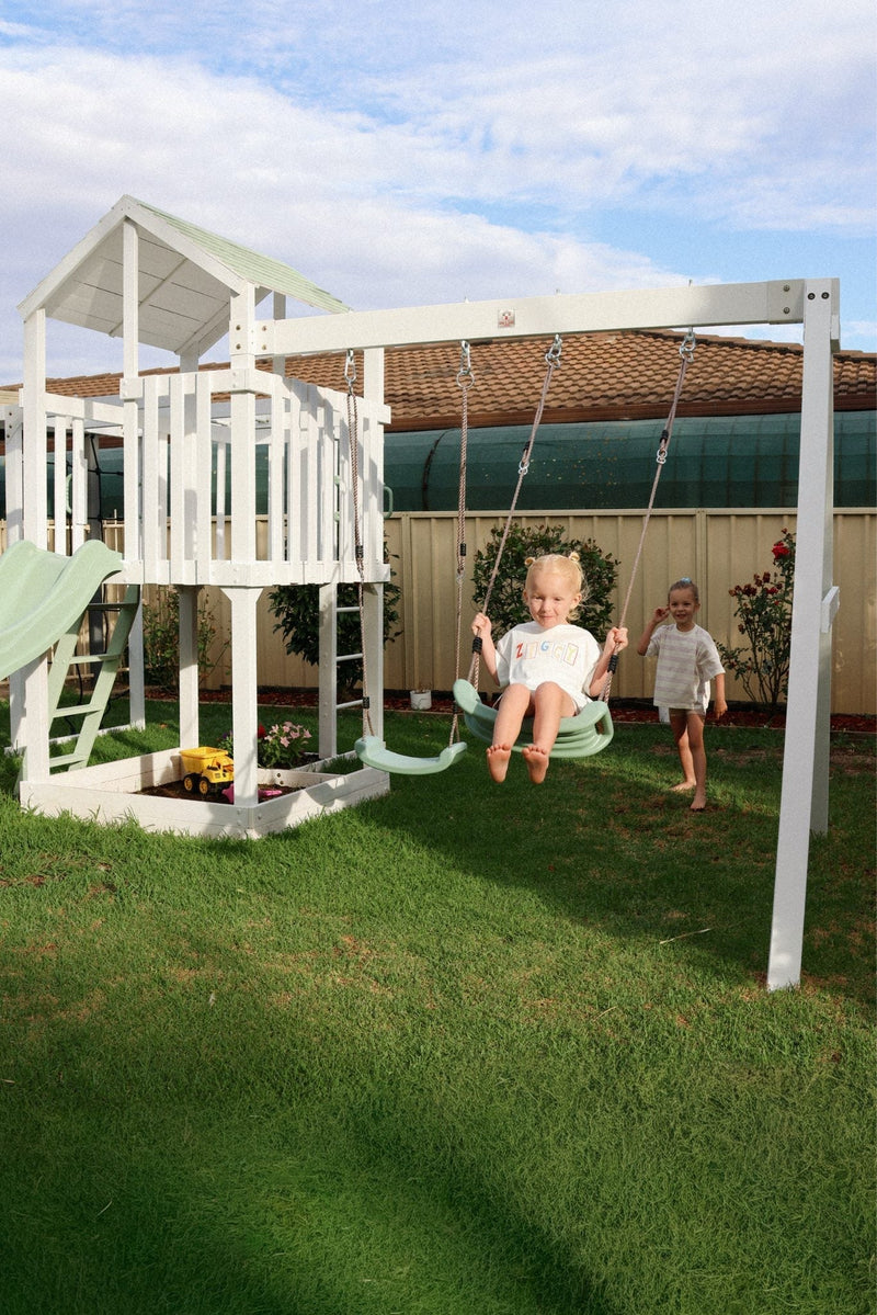 Children playing on River Fort outdoor play equipment featuring wooden structures, platforms, and climbing elements