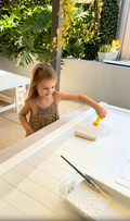 Young child engaged in creative painting activity at a wooden Billie Grand easel from Hudson Harlow kids furniture collection