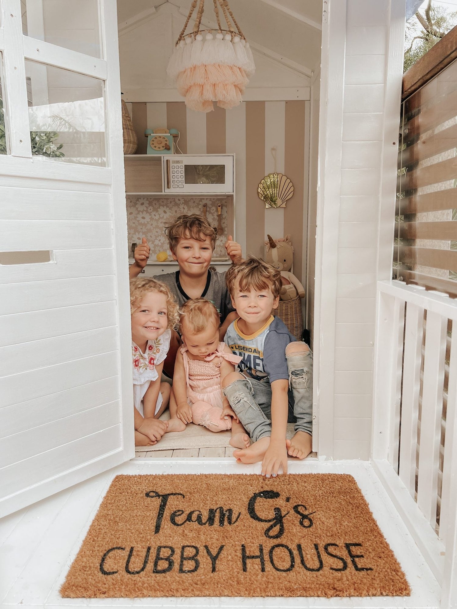 Millie Cubby house with young children sitting on the floor.