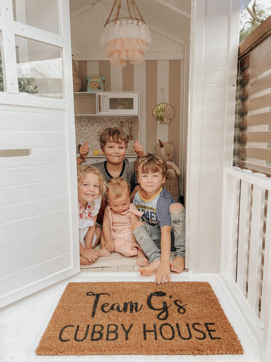 Millie Cubby house with young children sitting on the floor.