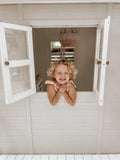 The Ultimate Cubby House Safety Checklist for Australian Parents - Hide and Seek Kids - Little Girl looking out cubby house window