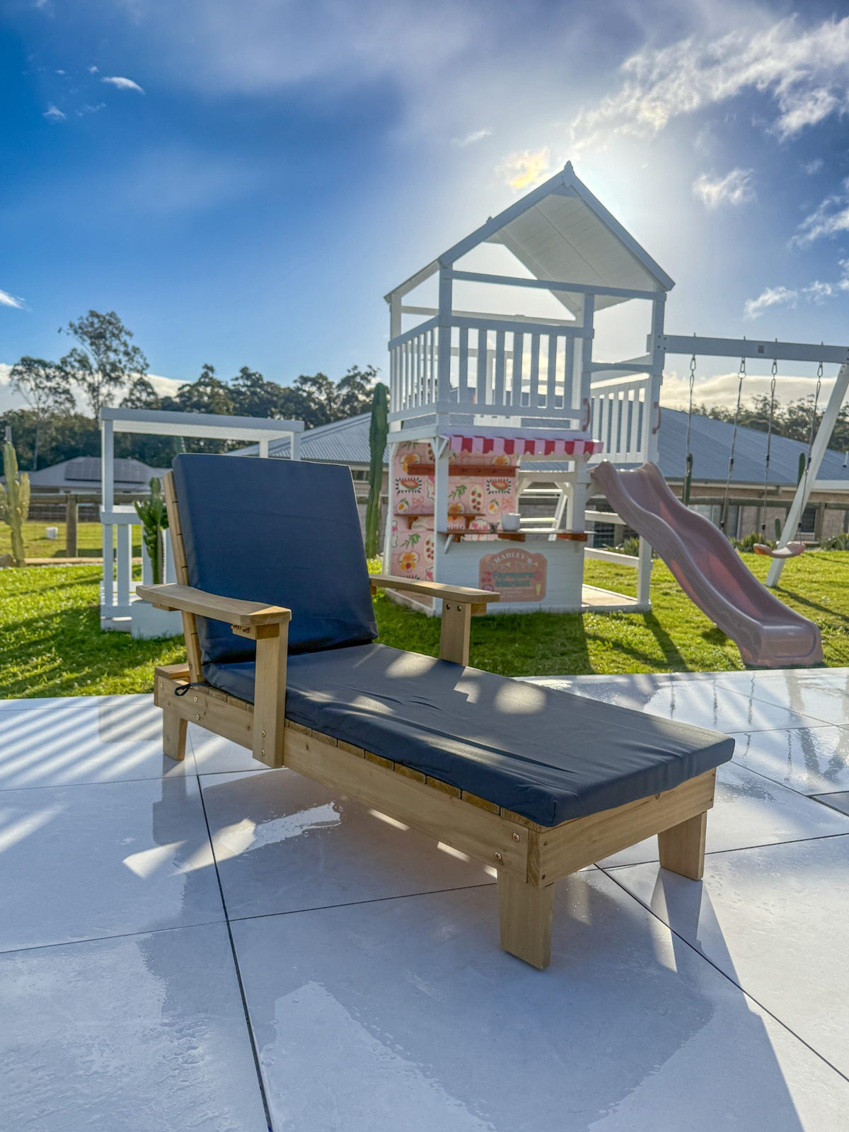 Kids sun lounger in unpainted natural timber stain, straight-on side profile