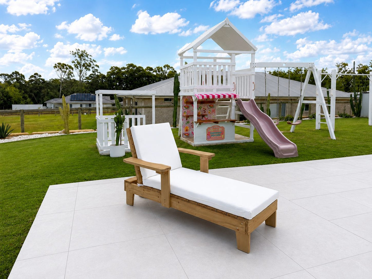 Kids solid timber sun lounger with cushion, full length side view in outdoor setting