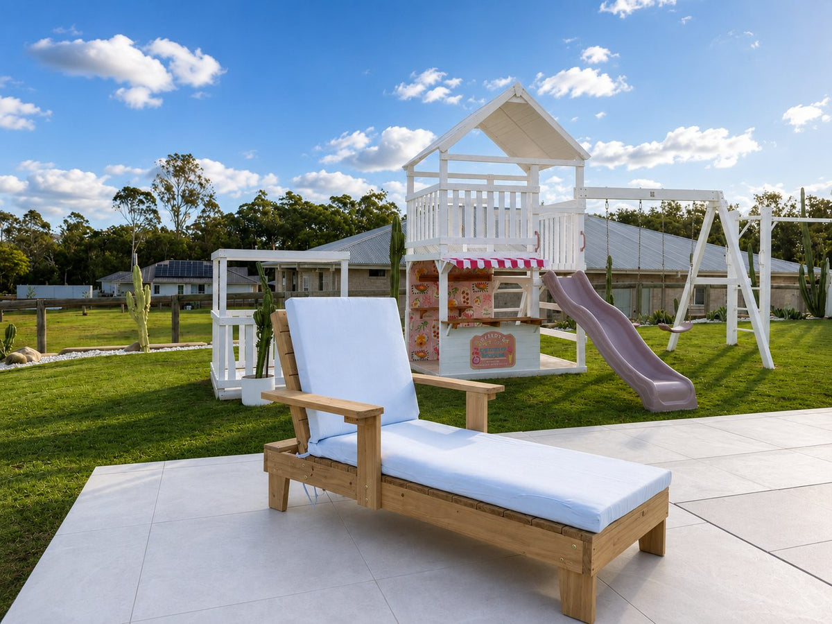 Kids timber sun lounger with reclined backrest and cushion, backyard lifestyle shot