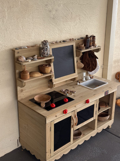 Child playing at Mud Kitchen Molly outdoor timber play kitchen with chalkboard and lower storage cabinet