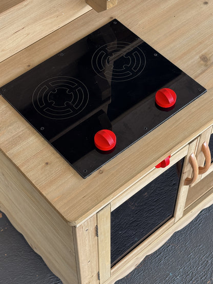 Mud Kitchen Molly front view showing etched black perspex stove top panel and knobs with storage below